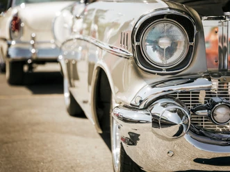 Musterbild Canva.png Nahaufnahme des Scheinwerfers und Chroms eines Oldtimers bei einem Oldtimertrefen.