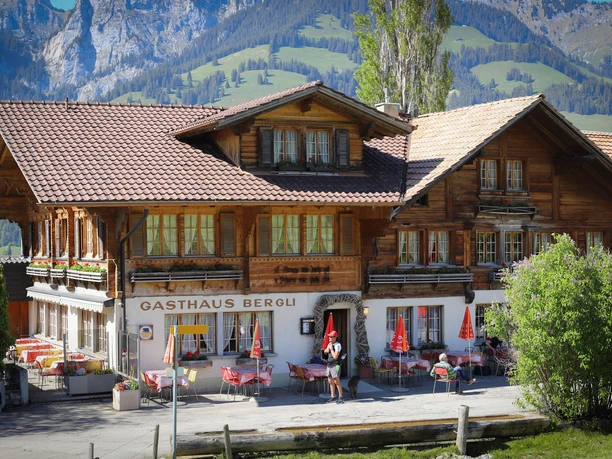 Gasthof Bergli exterior view Chalet-style restaurant with covered tables outside