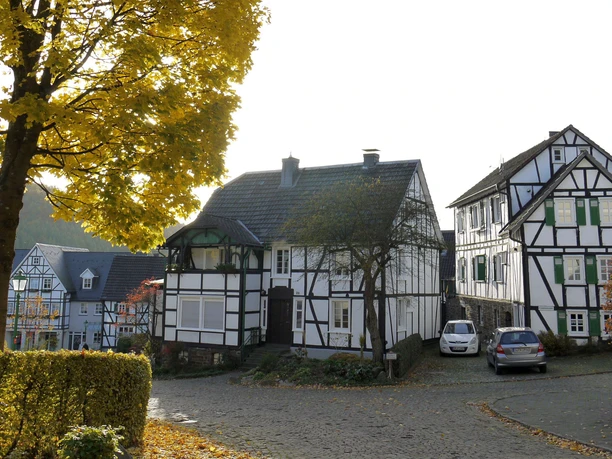 Kirchstraße im Herbst Fachwerkhäuser an einer herbstlichen Straße mit buntem Laub und Kopfsteinpflaster