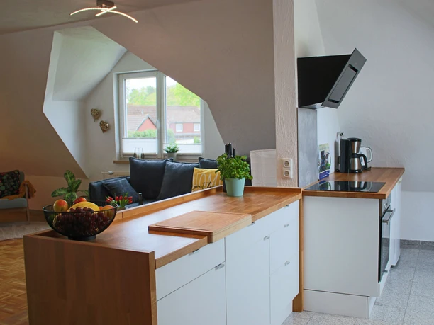 Ferienwohnung-Familie-Baasch-Küche.JPG Offene Wohnküche der Ferienwohnung mit Holztheke, Kochfeld und Blick auf den Wohnbereich.