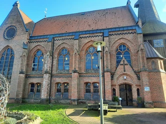 Die Backsteinkirche St. Jakobi in Wietzendorf mit ihren gotischen Fenstern unter blauem Himmel.