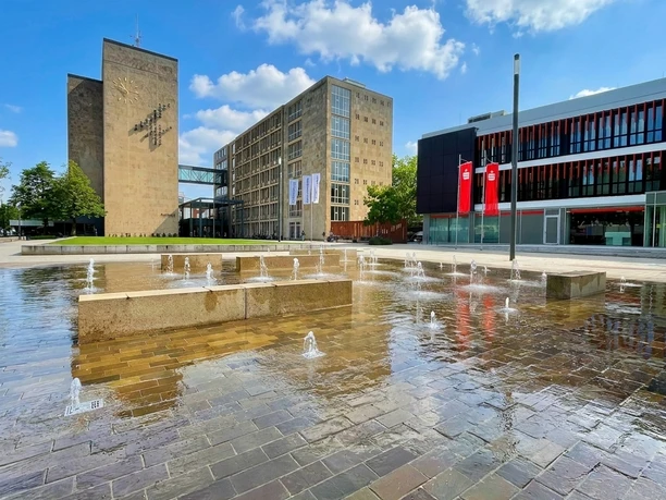 Brunnenanlage auf dem Konrad-Adenauer-Platz mit Wasserfontänen vor modernen Gebäuden
