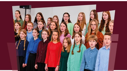 RJC Kinder- und Jugendchor singt in farbiger Kleidung vor hellem Hintergrund.