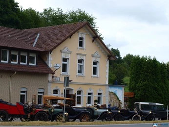 Restaurant & Café Am Steinbruch Historisches Gebäude im Grünen mit Oldtimern vor der Fassade, ideal für nostalgische Erlebnisse.