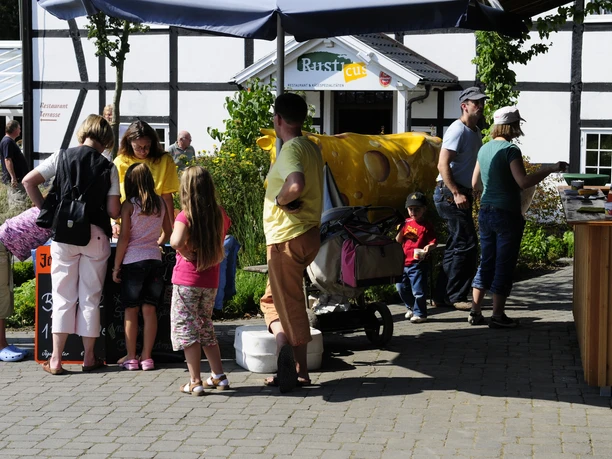 Hielscher Hof Eine Gruppe von Menschen steht auf einem gepflasterten Platz vor einem Restaurant mit Fachwerkfassade.