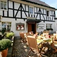 Lindenstübchen Ein traditionelles Fachwerkhaus mit Restaurantterrasse und gedeckten Holztischen im Freien.