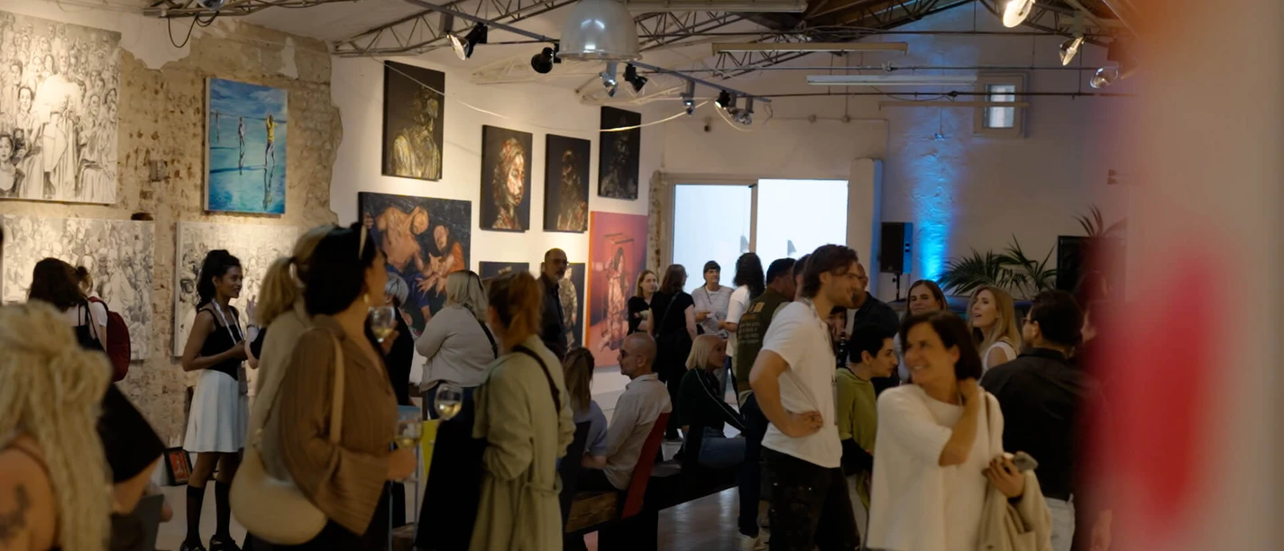 1000freund Gallery People look at paintings at a well-attended exhibition in an open gallery space
