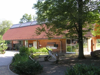 Wildpark Holzgebäude im Wald, Besucherzentrum mit Sitzbank außen