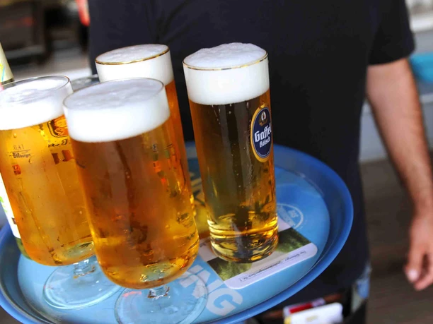 Beer Garden at Aachener Weiher A tray with several freshly poured beers in slender glasses is being carried