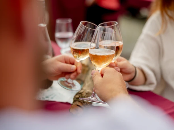 Waldbröler Weinfest Mehrere Personen stoßen mit gefüllten Weingläsern bei einem Fest an.