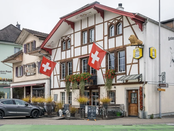 Restaurant Löwen Willisau Restaurant Löwen in Willisau mit Fachwerkfassade und Schweizer Fahnen an der Hauptstrasse