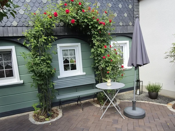 Sitzecke unter dem Rosenbogen