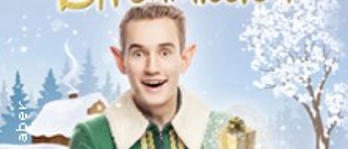 Ein als Elf verkleideter Mann hält ein Geschenk vor winterlicher Kulisse in einer Showgrafik.