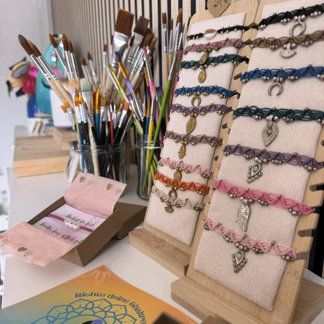 Muster.jpg Armbänder und Pinsel auf einem Regal.