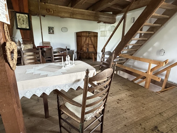Trauzimmer in der Behlmer Mühle Trauraum in der Behlmer Mühle mit Holzdielen, Balken und gedecktem Tisch für Gäste.