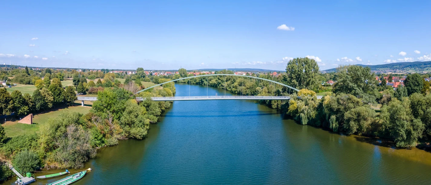 Kilianus-Brücke Fußgängerbrücke über Fluss mit Booten und Uferpark