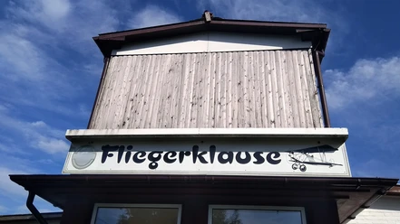 Fliegerklause St. Michaelisdonn Fassade mit Fliegerklause-Schriftzug und Flugzeug