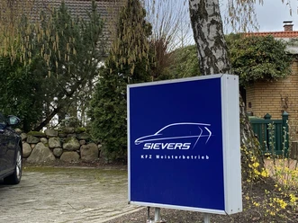 Sievers KFZ Meisterbetrieb.JPEG Firmenschild der Autowerkstatt Sievers in einem begrünten Einfahrtsbereich.