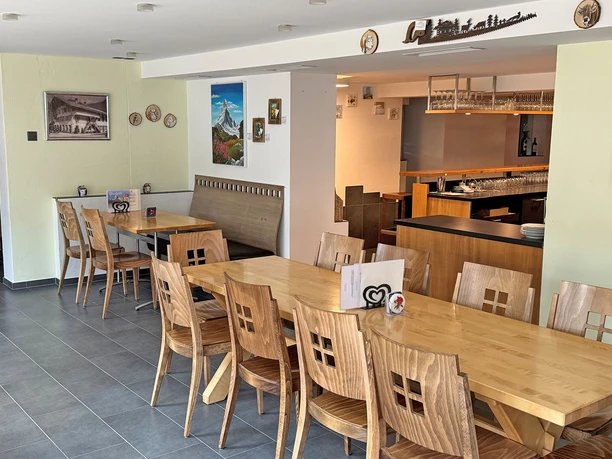 Salle de restaurant Rössli Salle à manger lumineuse du restaurant Rössli, avec des tables et des chaises ainsi que divers objets accrochés aux murs, qui sont à vendre