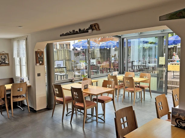 Wintergarten Restaurant Rössli Heller Wintergarten mit Sitzgelegenheiten und dekorierten Wänden mit Artikel, welche auch zum Verkauf stehen