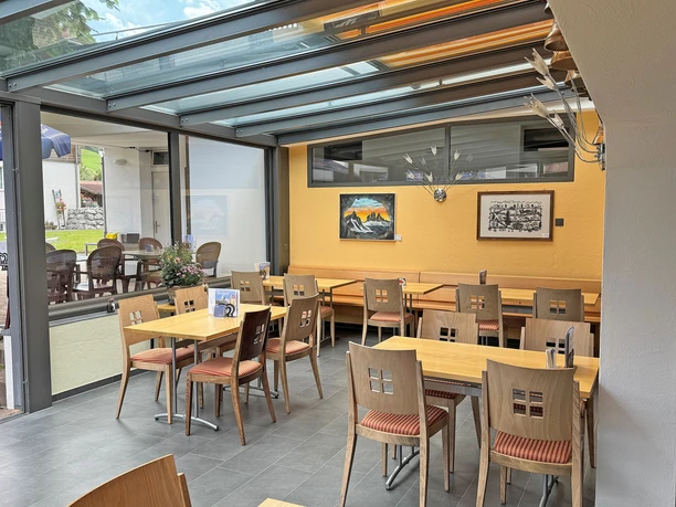 Véranda du restaurant Rössli La véranda lumineuse, dont les murs sont ornés de tableaux, est équipée de tables et de chaises
