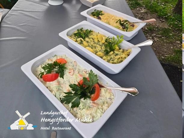 Grillbuffet Hengstforder Mühle_Magdalena Oberhauser.jpg Reichhaltiges Salatbuffet mit diversen Beilagen, angerichtet auf einem langen Tisch im Freien.
