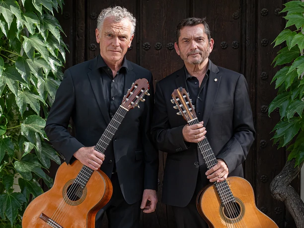 Wiedemann & Gallardo del Rey.jpg Zwei Gitarristen in Schwarz vor Holztür
