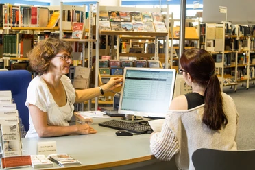 Beratungsgespräch_WEB.jpg Eine Mitarbeiterin der Bibliothek berät eine Besucherin an einem Computerarbeitsplatz.