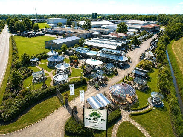 Luftbild Firma Hoklartherm.jpg Luftbild des Ausstellungsgeländes von Hoklartherm mit diversen Glasbauten in einer Parkanlage.