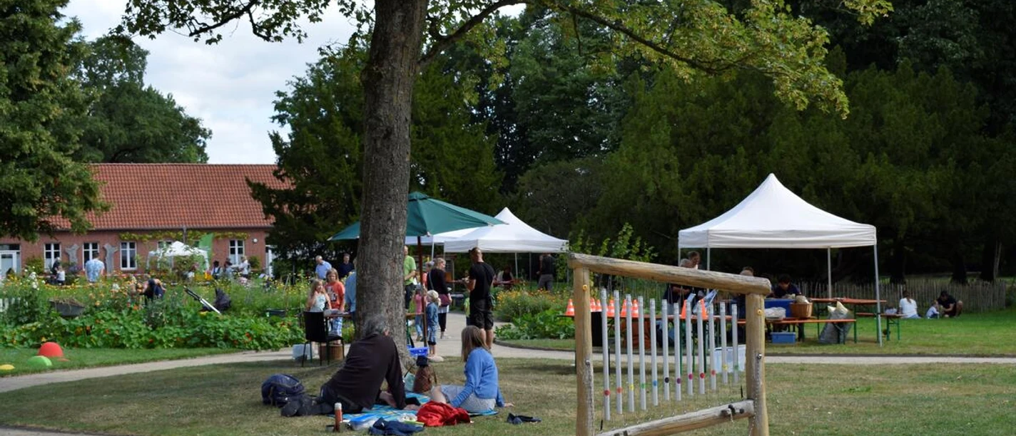 3596_1283_1_g.jpg Besucher des Familienpicknicks im Park der Evenburg entspannen auf einer Wiese mit Zelten.