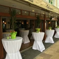 Terrasse Auf dem Bild ist die Terrasse des Restaurants zu sehen, ausgestattet mit elegant weiß eingedeckten Stehtischen. Die Atmosphäre ist einladend und perfekt für ein entspanntes Essen im Freien.
