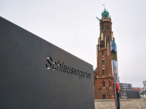 210707 (c) Sönke Mahlstedt_Erlebnis Bremerhaven_WEB.jpg Hinweistafel Schleusengarten mit dem Simon-Loschen-Leuchtturm im Hintergrund