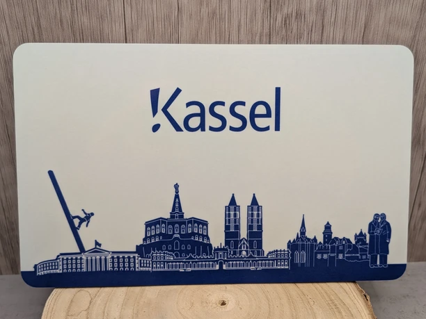 Ein Schneidebrett auf dem einigen Sehenswürdigkeiten von Kassel in blau abgebildet sind.