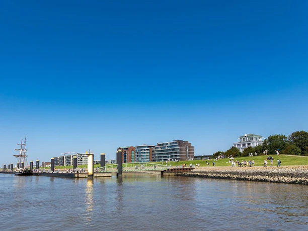 CAL_9336 (c) Carmen Lindemann_Erlebnis Bremerhaven_CC0_WEB.jpg Blick vom Wasser auf die Schlepperpier und den Deich mit der Kommodore-Ziegenbein-Promenade