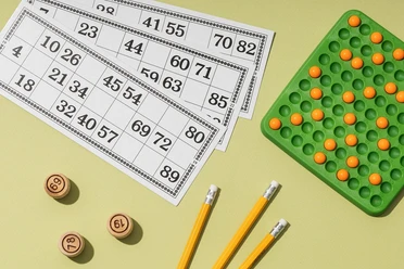Bingo Bingoscheine, eine Zahlentafel und Stifte versprechen einen geselligen Spieleabend.
