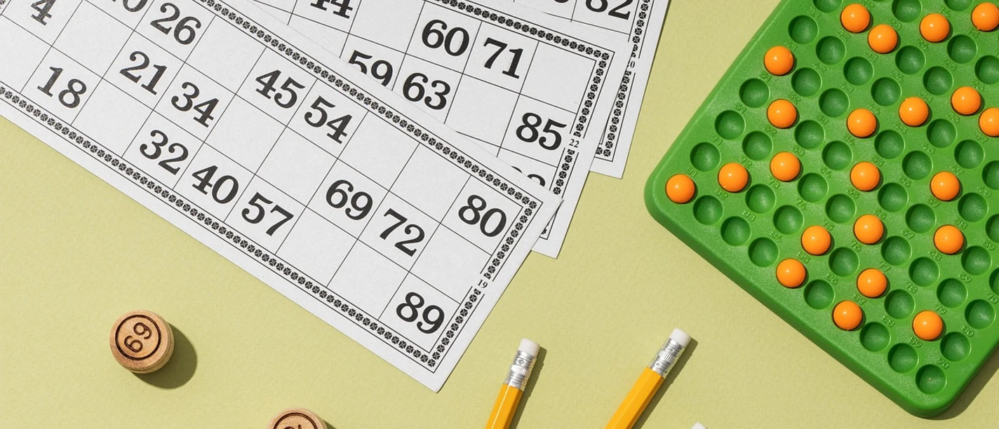 Bingo Bingoscheine, eine Zahlentafel und Stifte versprechen einen geselligen Spieleabend.