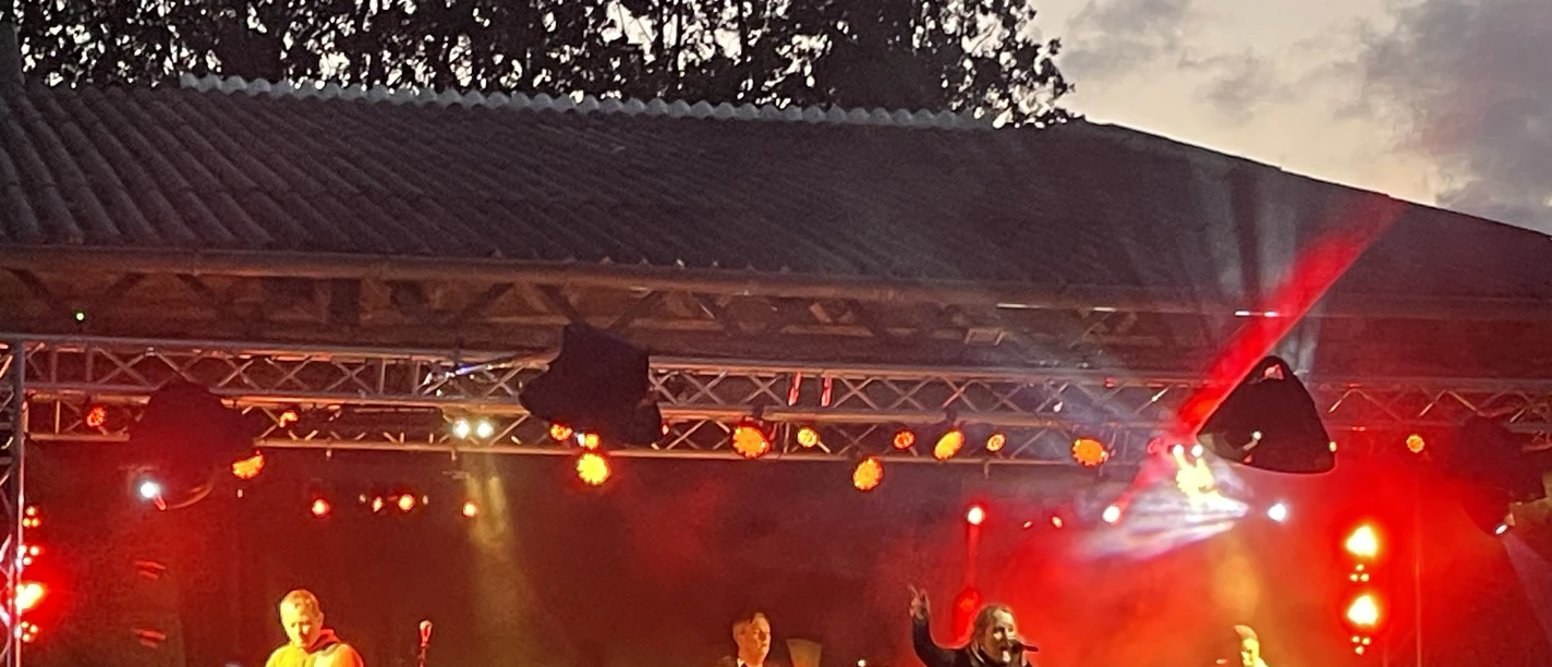 Salzwiesn-Deichbrett.jpeg Bühne mit viel Lichttechnik - Rockband mit singender Frontfrau