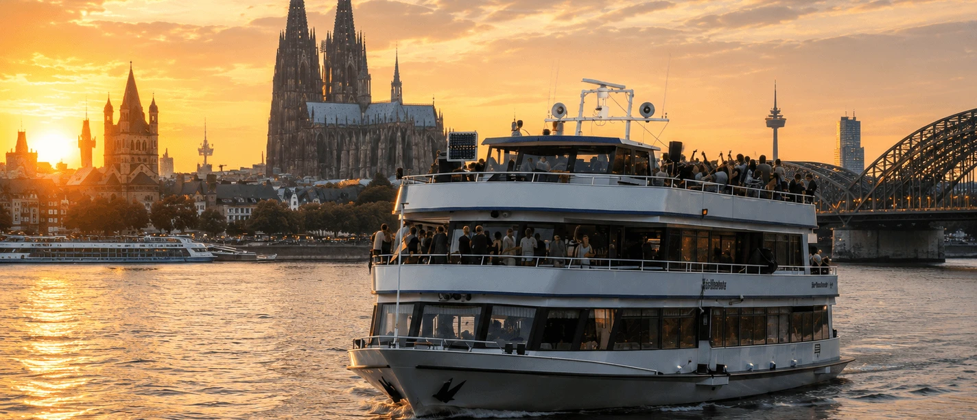 MS Beethoven Party boat on the Rhine in front of Cologne Cathedral and the Hohenzollern Bridge at sunset