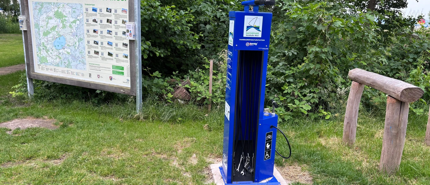 Fahrradreparaturstation am Naturpark-Haus in Mardorf. Ein blaues System zum Schrauben festziehen, Reifen wechseln oder Luft aufpumpen.