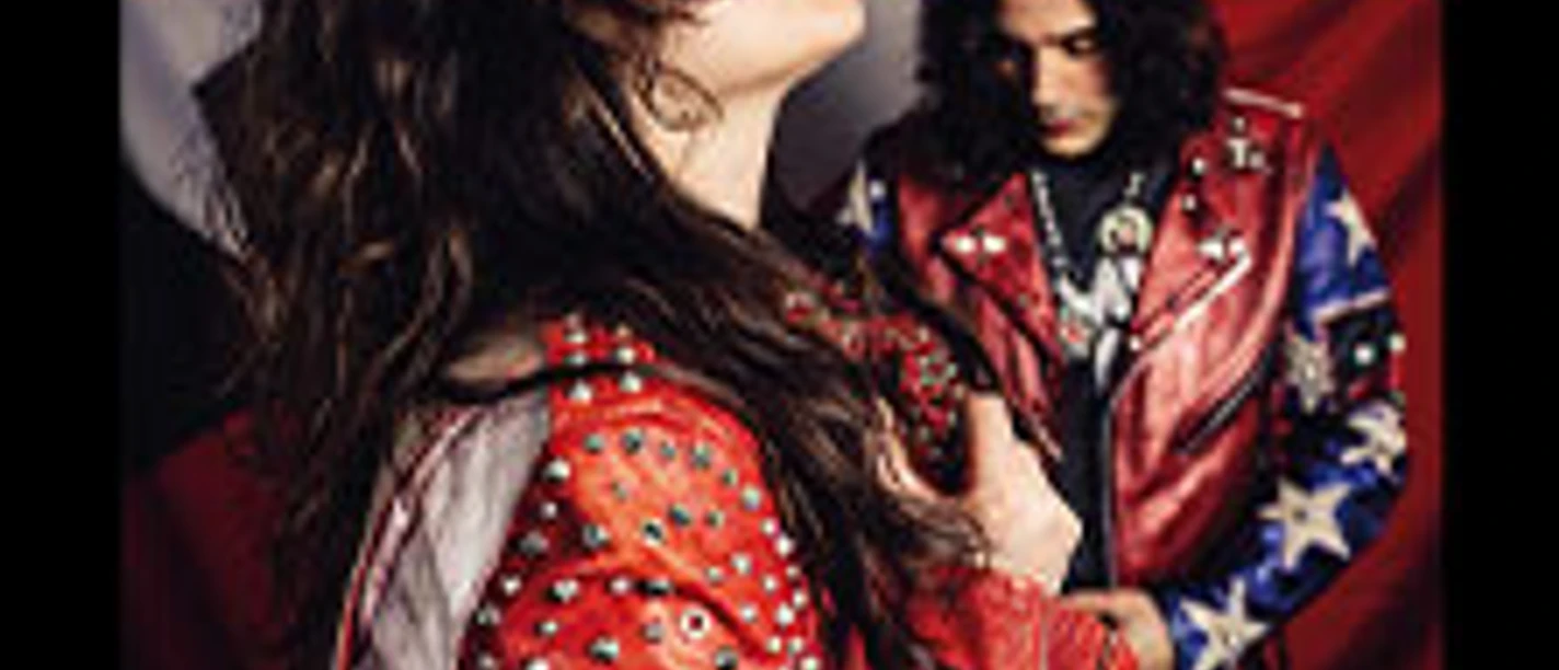 Bandfoto von The Last Internationale: Sängerin im Vordergrund, Musiker vor rotem Hintergrund