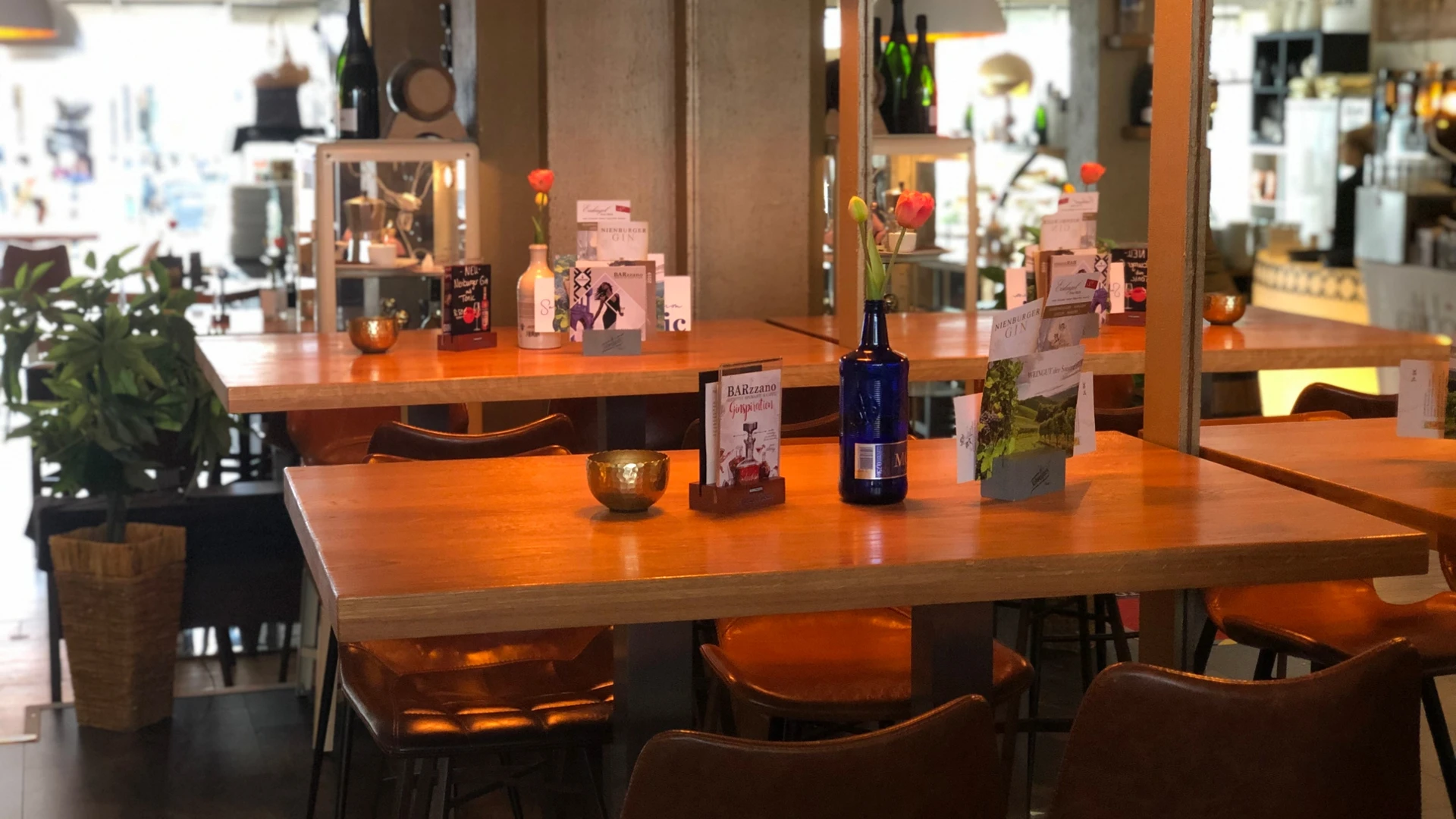 Modern café with wooden tables, leather armchairs and decorative details in warm light.
