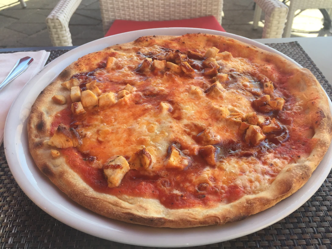 Pizza Pizza mit knusprigem Rand, belegt mit würzigem Tomatensugo, üppigem Käse und gegrilltem Geflügel.Pizza with a crispy crust, topped with spicy tomato sauce, rich cheese and grilled poultry.Pizza med sprød bund, toppet med smagfuld tomatsauce, fyldig ost og grillet fjerkræ.Pizza met een knapperige korst, belegd met smakelijke tomatensaus, rijke kaas en gegrild gevogelte.