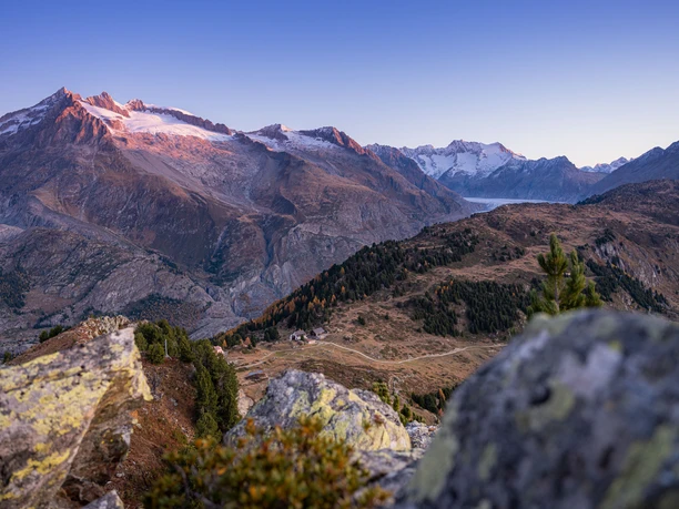 Herbstlandschaft in der Aletsch Arena Herbstliche Berglandschaft beim Teamerlebnis Slow Hike in der Aletsch Arena mit Blick auf den Aletschgletscher und alpine Gipfel.