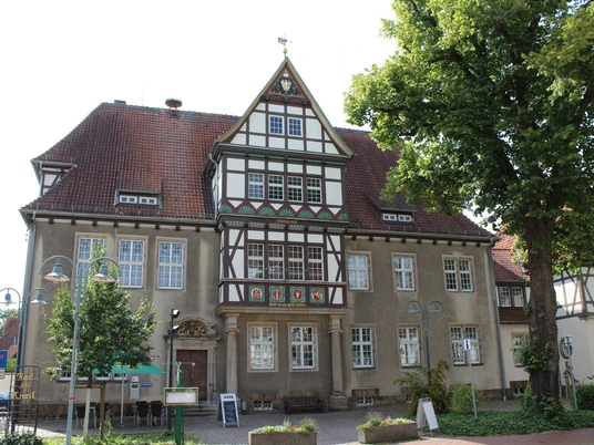 Altes Amtsgericht Historisches Fachwerkgebäude in einem grünen Stadtbereich mit dekorativen Wappen an der Fassade.