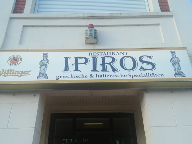 Entrance area of the restaurant Ipiros with a sign for Greek and Italian specialties.