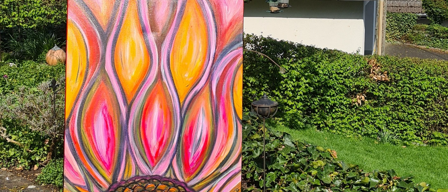 Vernissage im Feng Shui Garten Buntes Blumenbild auf einer Staffelei in einem sonnigen Garten in Wiehl