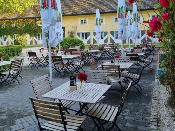 Terrasse im Burgcafé Haus Graven in Langenfeld Terrasse des Burgcafés Haus Graven in Langenfeld. Holztische, Schirme und Rosen vor dem historischen Bau der Wasserburg