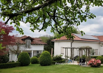 Aussenansicht_Privatpension Waldbröl Außenansicht der Privatpension Waldbröl mit Garten, Bäumen und roten Ziegeldächern