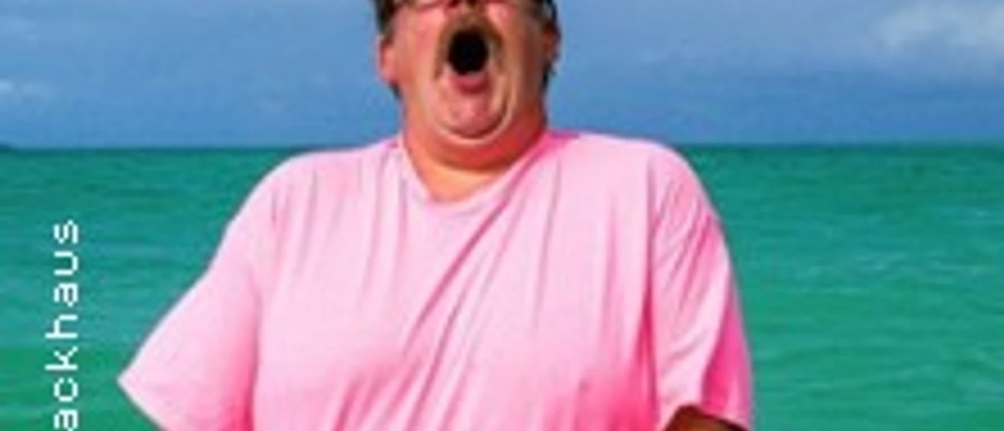 Mann im pinken Shirt steht im türkisfarbenen Wasser und ruft mit offenem Mund.