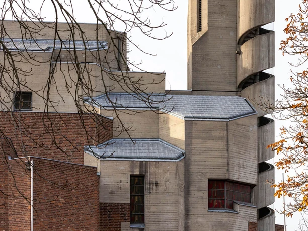 Betonturm der Kirche Christi Auferstehung in Köln-Lindenthal hinter kahlen Ästen